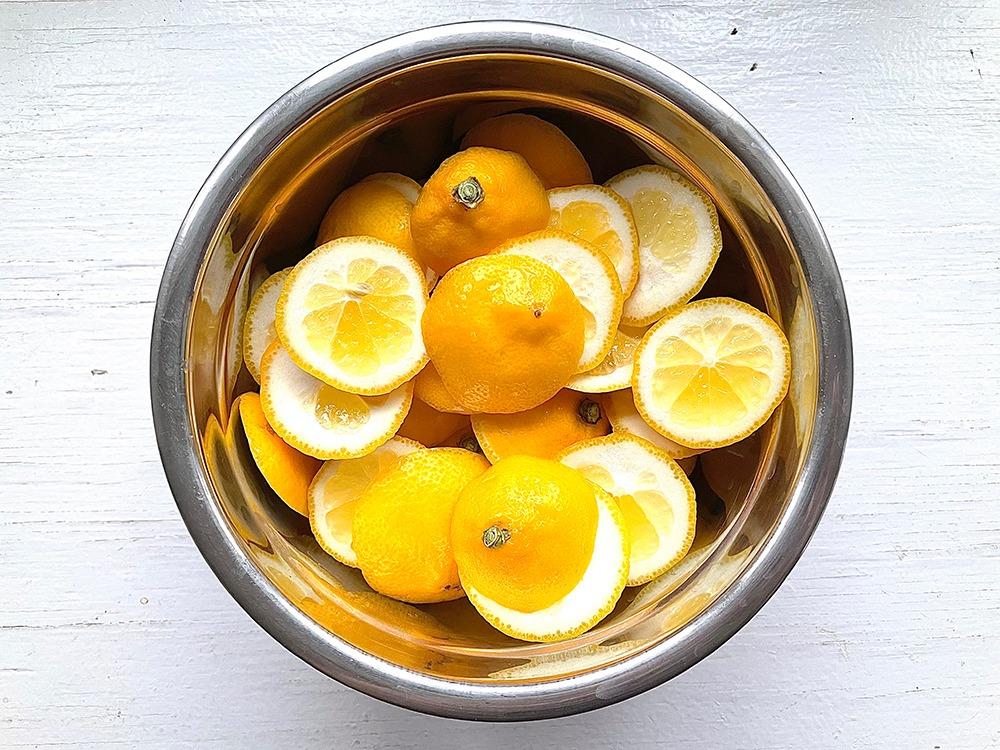 metal bowl of meye lemon ends sliced up on wooden table